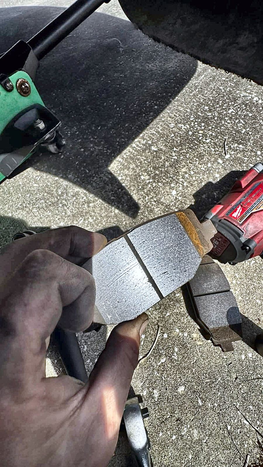 Worn brake pad next to its new replacement